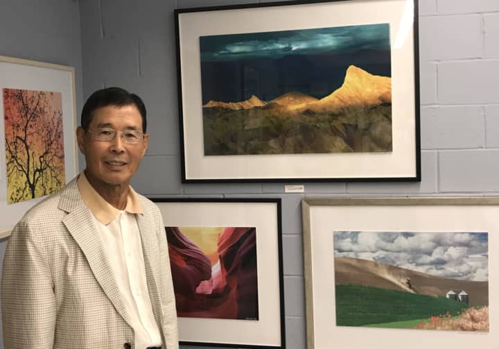 Daniel Lee stands in front of some of his photographs at the Totowa Public Library.