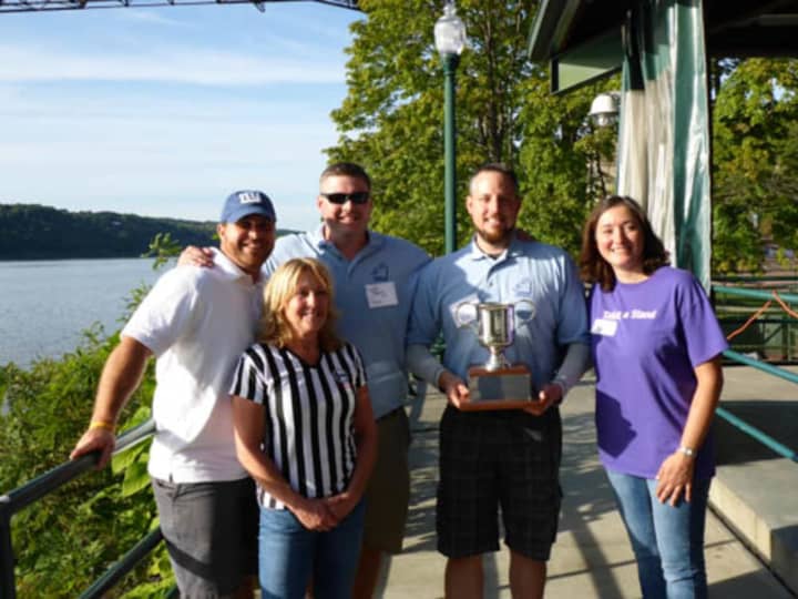 Grace Smith House Executive Director Michele Pollock Rich and Board Chair Barbara Mauri award present the 2015 winners, Michael Davis and Matthew Repp from Meyer Contracting, with the Afternoon of Champions trophy.