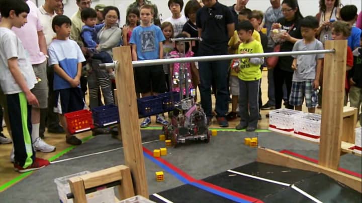 Students and parents watch what one robot can do, at George Washington Middle School&#x27;s first Robotics Showcase, in 2014.