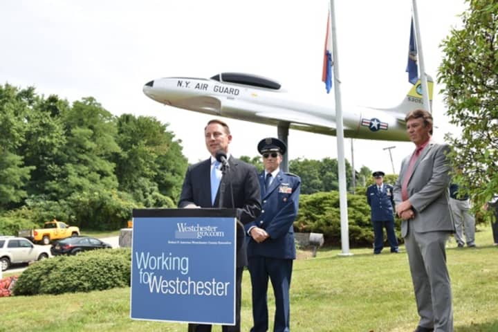 Westchester County Executive Robert Astorino speaks during a rededication ceremony welcoming back a World WarII training airplane that had been removed from the Westchester County Airport for restoration.
