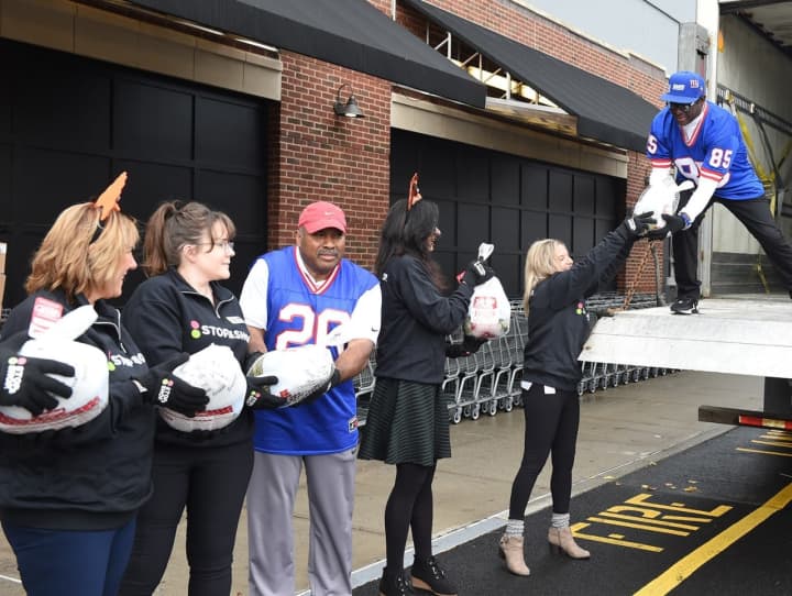Former New York Giants running back  Joe Morris (left) and wide receiver Stephen Baker (on truck) worked alongside Stop &amp; Shop associates to deliver 500 Thanksgiving turkeys to the Food Bank of the Hudson Valley.