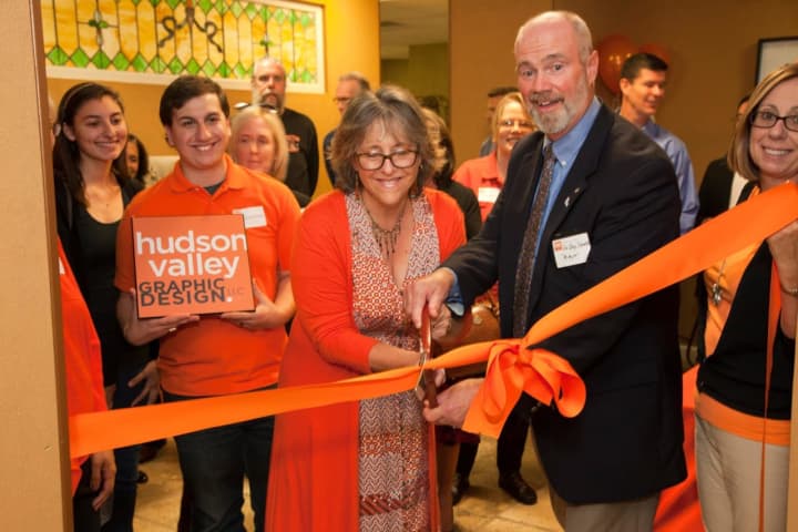Croton-on-Hudson Mayor Greg Schmidt assists Hudson Valley Graphic Design owner Janeen Violante with the official ribbon cutting ceremony.