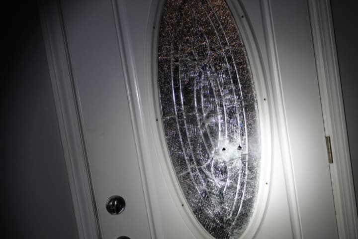 Damage to the home&#x27;s front door during a drive-by shooting.