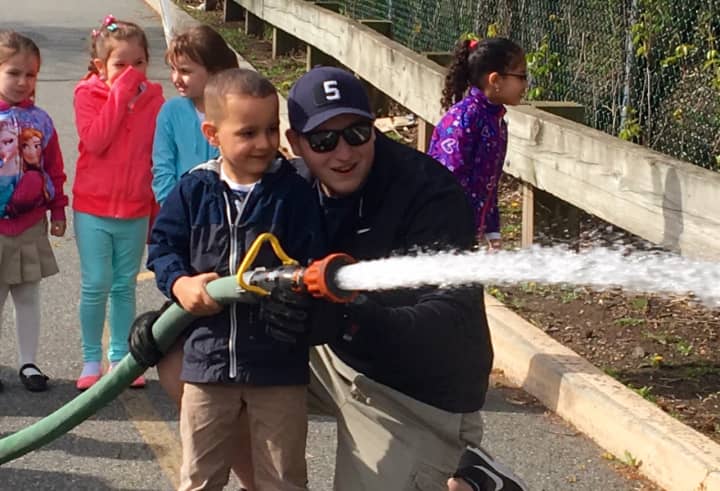 A firefighter in the making? Assistant Engineer Nick Kopacz showed school children how to properly extinguish a fire.