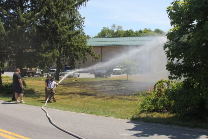 Mahopac firefighters douse the flames of the brush fire.