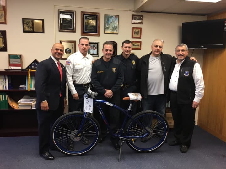 BMW officials and the Paterson Police Department with its new bicycle.
