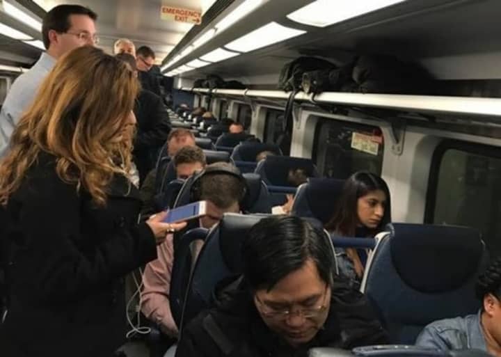NJ Transit commuters pack into a train car.