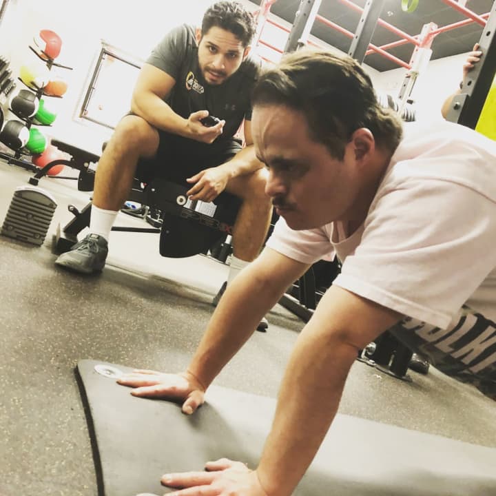 Alex Rivera holds a plank with trainer JC Merino at Retro Fitness of Hackensack. The pair work together twice weekly, running through strength and cardio circuits that Alex say help him become a stronger fighter as a karate black belt.