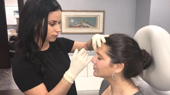 Veronica Oliveros injects botox into a client at The Kaplan Center in Edgewater.