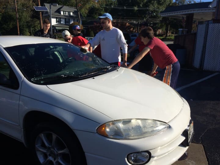 Glen Rock hockey players wash down one of the cars at a fundraiser for the program Saturday, Oct. 10 on South Maple Avenue.