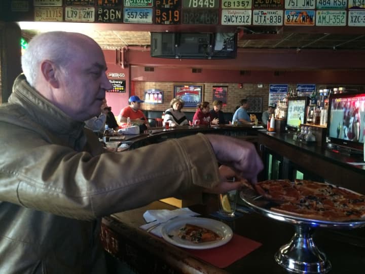 Ed Ogle of Lyndhurst goes for another slice of his pepperoni and olives pizza at New Park Tavern in East Rutherford Oct. 17.
