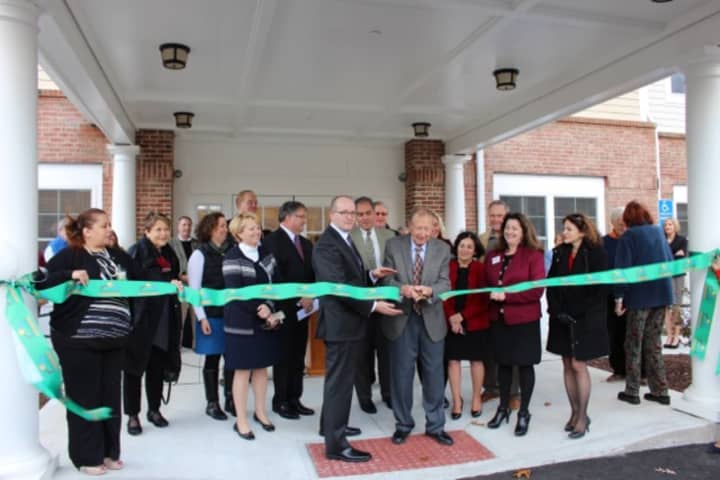 George Ciaccio cuts the ribbon to officially open Wilton Commons Congregate. Nick Lundgren, deputy commissioner of the state&#x27;s Dept. of Housing, is left of Ciaccio, and Renee Dobos, CEO of MHA, is to the right.