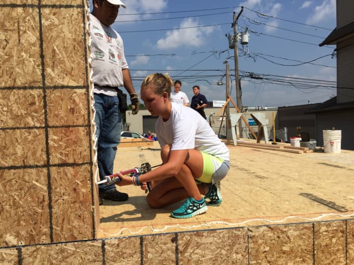 Fairfield University Student Emily Barr works at a Habitat for Humanity construction site in Bridgeport on Wednesday. The new home is being constructed in honor of Pope Francis, who will visit the U.S. later this month. 