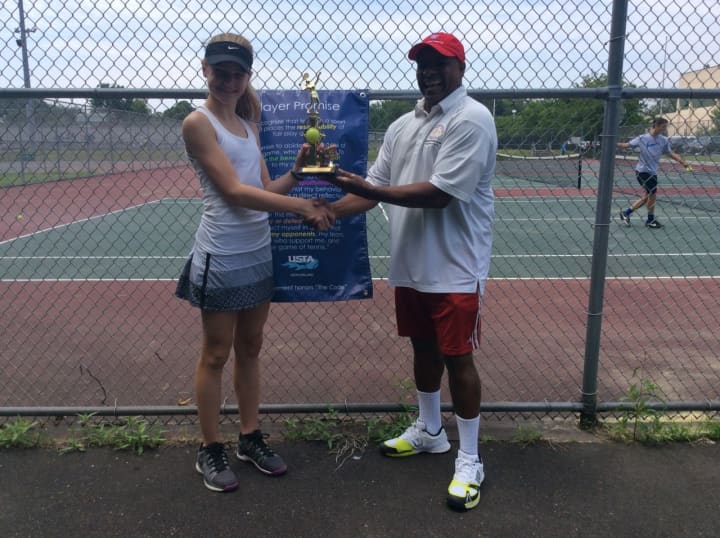 Marvin Tyler of Slammer Tennis World, right, awards a trophy to one of the tournament participants.