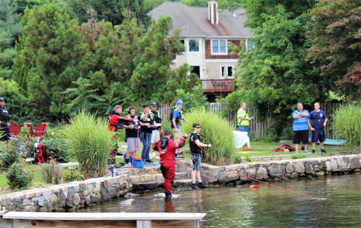 Divers, dive tenders, EMT and ambulance crew and Incident Command Chief Brian Sacher of the Mahopac Falls Volunteer Fire Department near the area where the body was recovered.