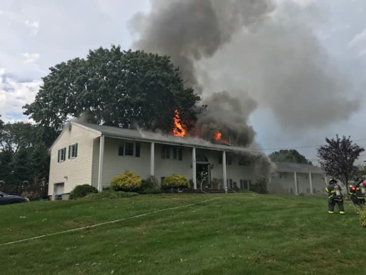 A home in Norwalk is engulfed in flames reportedly caused by a lightning strike, according to the Norwalk Fire Department.