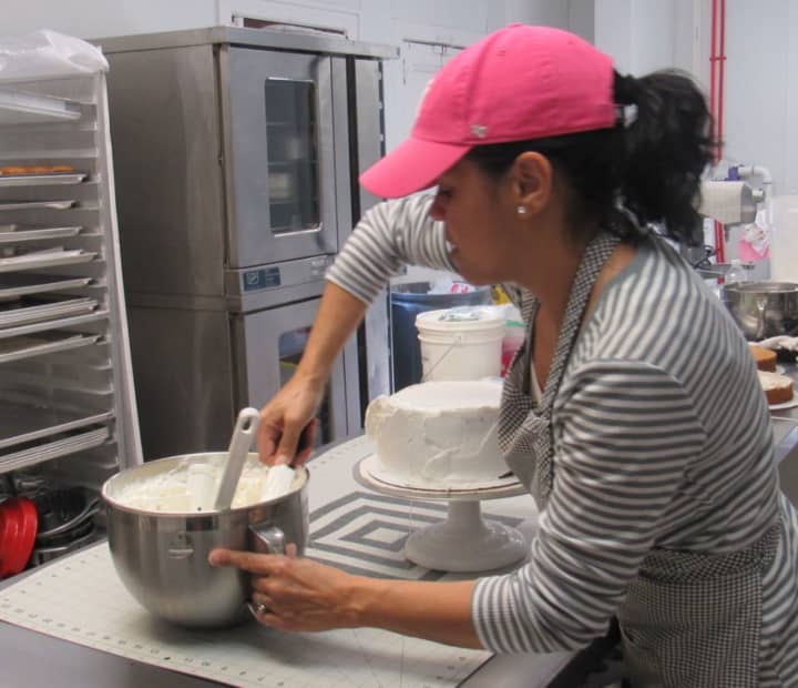 Regina Heredia works on a red velvet cake she will slice up for sale. Cindy Capitani