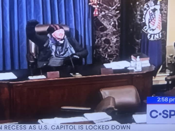 One of the rioters who stormed the Capitol building took to the dais in the chamber.