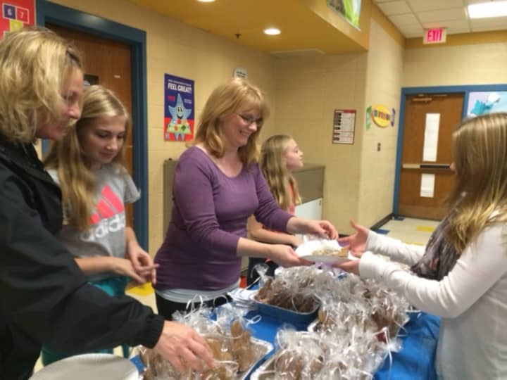 Stacie Rich, Mackenzie Rich, Dawn Kascak and Aubrie Rich pass out volunteer at the Eli Whitney School Holiday Social with Grace Kascak (r).