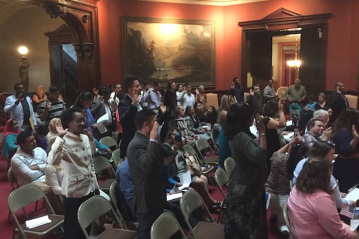 A group of 25 immigrants take the Oath of Allegiance to become United States citizens at a naturalization ceremony at the Lockwood-Mathews Mansion Museum in Norwalk.