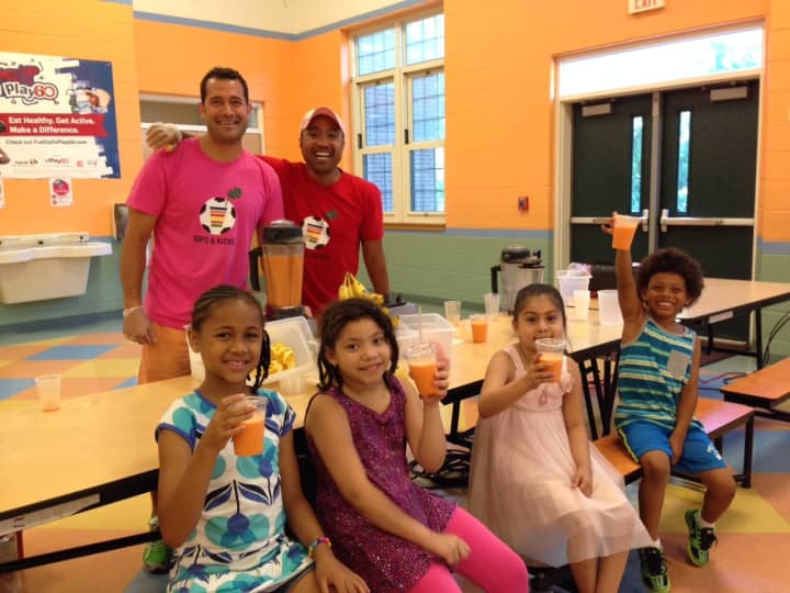 Local dads Chad Dictenberg (left) and Andy Pada served up free healthy smoothies to the students at the Dr. John Grieco Elementary School in Englewood.