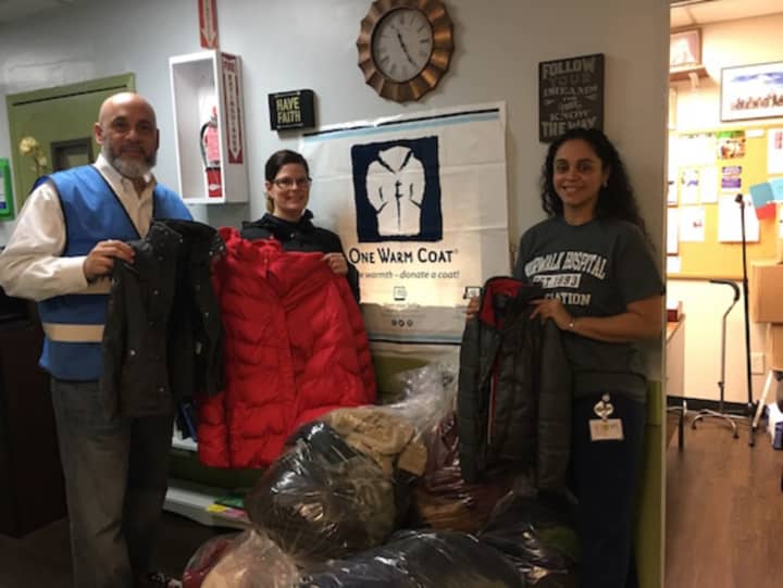 Frank Concepcion, director of operations for The Open Door Shelter in Norwalk, welcomes the delivery of donated coats from Norwalk Radiology employees Kelly Turnage, of Hamden, and Jessica Solano, of Stratford, Oct. 21, 2016.