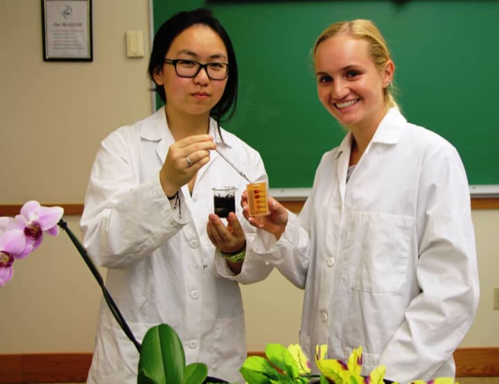 Madison Miles (left) with Katherine Siciliano in the school lab testing their work at Sacred Heart Greenwich.
