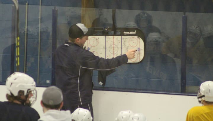 Coach Anthony Tabbacchino goes over plays with the Indian Hills hockey team.