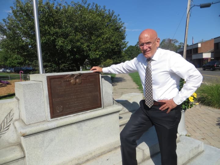 Harrison Mayor/Supervisor Ron Belmont stands next to the base of World War I monument that toppled over in June. The Harrison Village Board approved spending money to replace the &quot;Doughboy&quot; statue at Ma Riis Park.