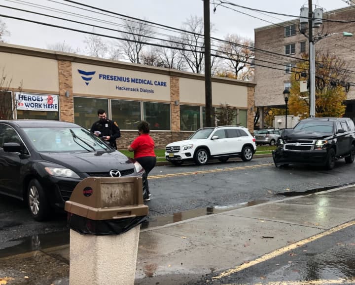 A Family Dollar worker brings water to the driver involved in a crash outside the Passaic Street store Thursday morning.
