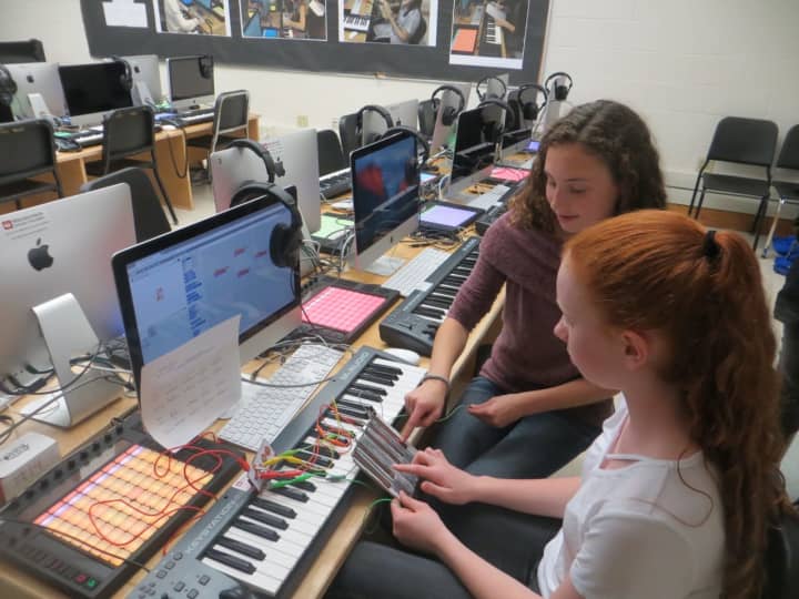 Hannah Israel, front, and Anna Daum, make music with a handmade gadget -- basically, cardboard and copper wires -- that is hooked up to a computer. The Hommocks Middle School&#x27;s new eMusic Lab was officially launched Tuesday.