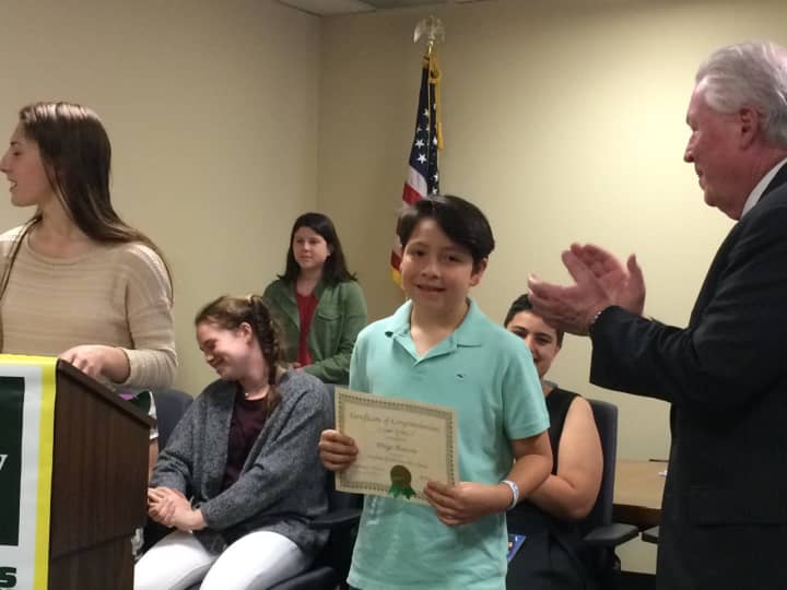 Diego Alarcon receives a certificate for his Earth Day artwork from First Selectman Michael Tetreau.
