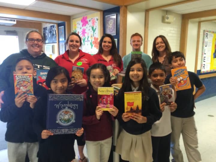 Madison School third-graders in Bridgeport hold up the free books they&#x27;ll take home, thanks to a book drive at Sacred Heart University of Fairfield.