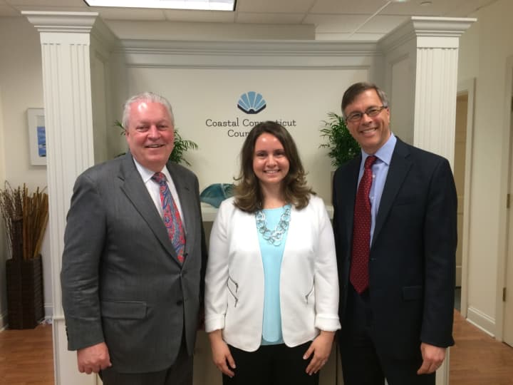 First Selectman Michael Tetreau, left, and Economic Development Director Mark Barnhart, right, congratulate Alyssa Kolesar, owner of Coastal Connecticut Counseling in Fairfield.