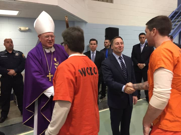Cardinal Timothy Dolan and County Executive Astorino greet prisoners after the Mass service.