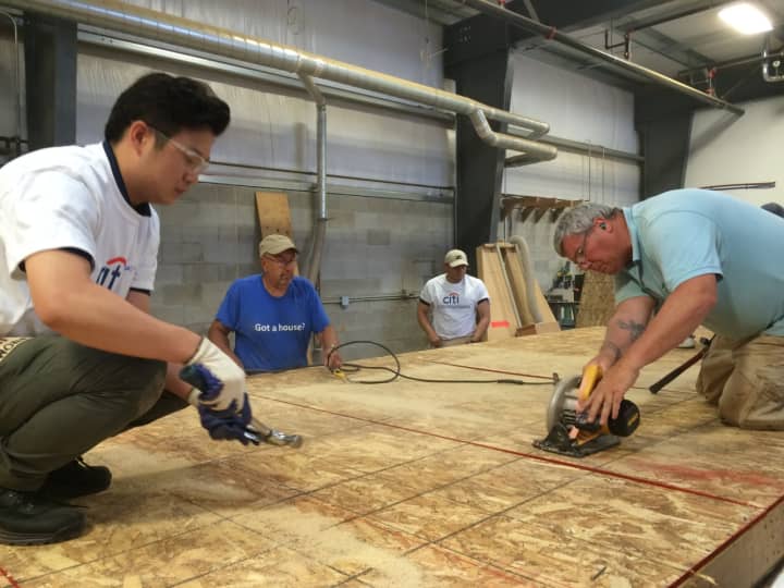 Citi volunteers help build walls Friday for a new Habitat for Humanity home in Bridgeport.