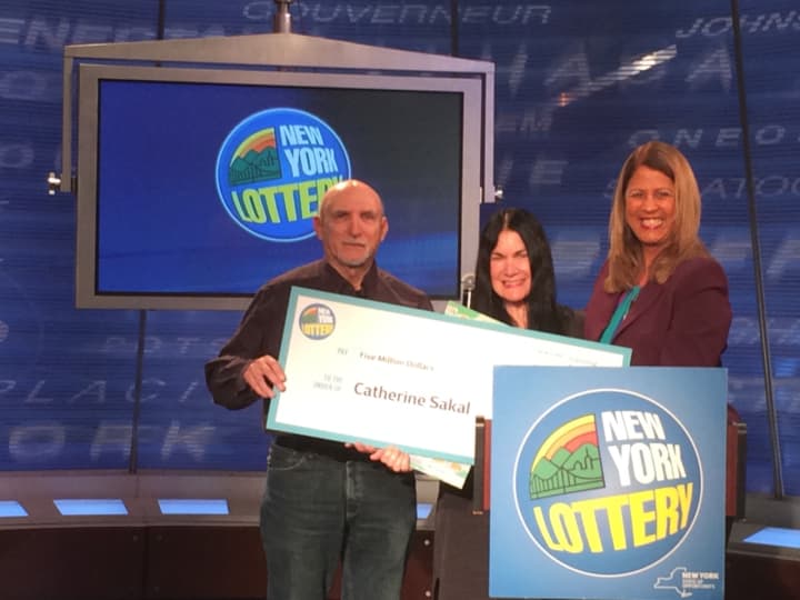Catherine Sakal, an accountant from Dutchess County, collects the $3.3 million after-tax balance of her $5 million Lottery scratch-off ticket purchased Jan. 4 in Rhinebeck. She is shown with her husband, William, as Yolanda Vega presents the check.