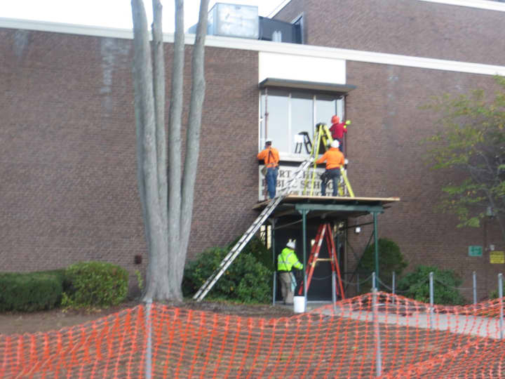 Workers outside the Board of Education and District office entrance of Port Chester-Rye Union Free District on Tuesday, Oct. 31. Ongoing emergency repairs have kept Port Chester Middle School closed to students since Friday, Oct. 27.