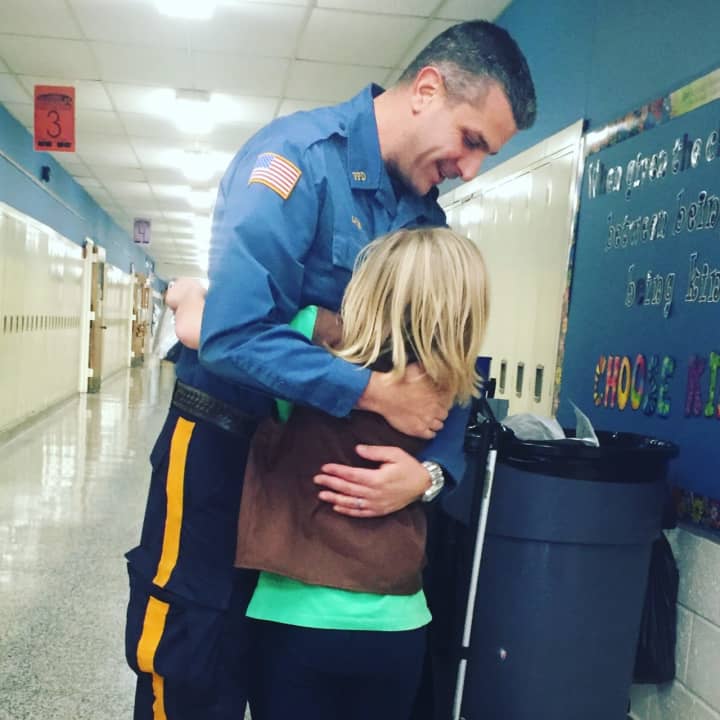 Paramus Police Officer Brian Linden surprises Delaney Boettcher, 7.