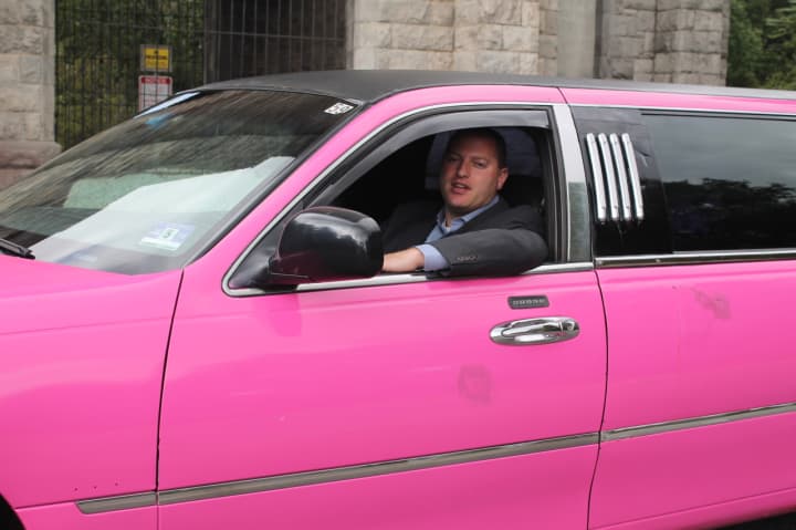 Josh Schnee, owner of Advanced Car Service, behind the wheel of the pink limo.