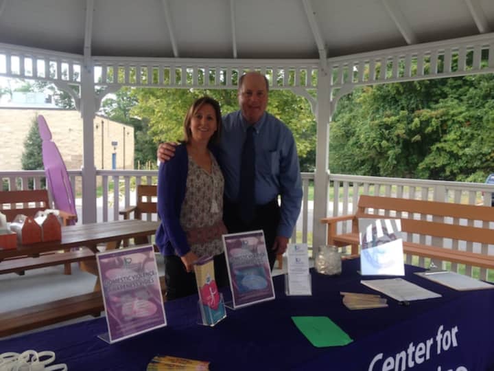 Beth Andrews, volunteer and intern coordinator with the Center for Family Justice, and Mark Antonini, CFO and COO of the Center for Family Justice, pause while setting up for the domestic violence awareness vigil in Easton on Monday, Oct. 3.