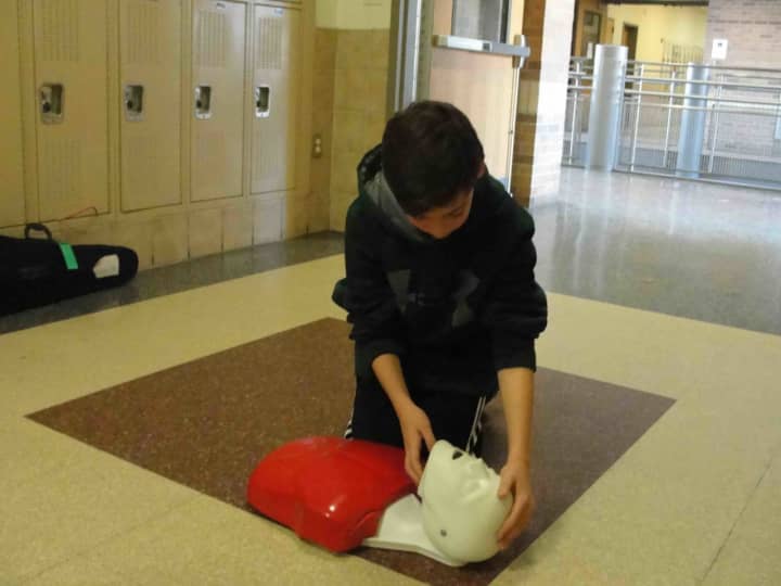An eighth-grader at Irvington Middle School performs CPR on a mannequin.