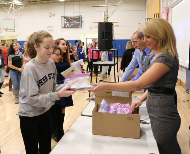 News 12 Westchester reporter Kristina Cartwright helps distribute copies of  &quot;City of Ember.&quot; at the “One Book, One School” kick-off literacy event.