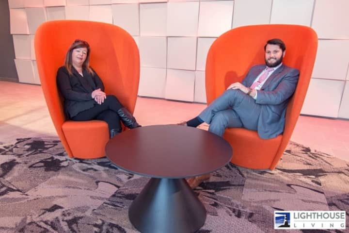 Lynne Zappia and Julian Diaz, of BHG Rand Realty,  are dwarfed by &quot;The Jetsons&quot;-like, but cozy, chairs in the lobby of The Light House, a new luxury apartment building in Port Chester.
