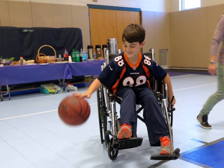Meadow Pond Elementary School student learns what it would be like to play basketball in a wheelchair during Differences Day.