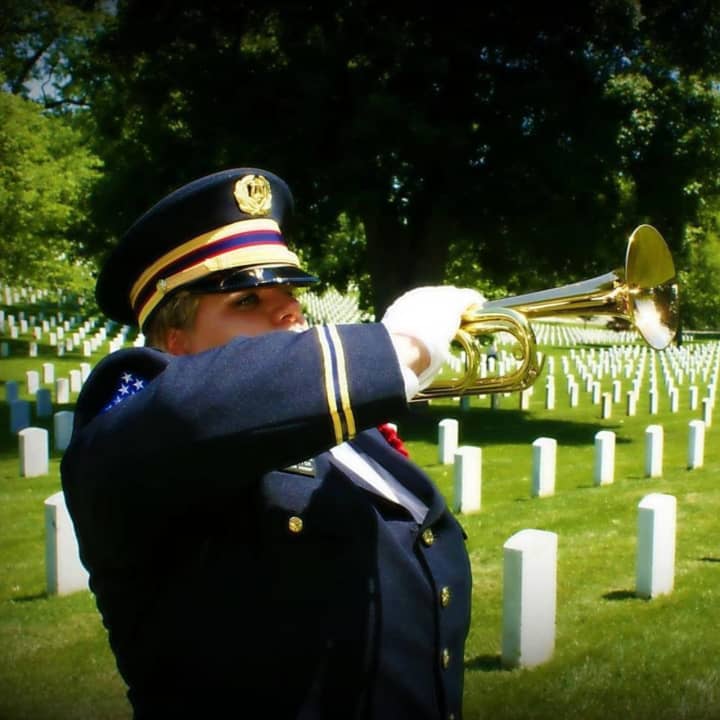 Bugler Dani Masterson of Wappingers Falls has played Taps at thousands of ceremonies, most of them funerals for veterans. Shown playing at Arlington National Cemetery, she was recently recognized by the Exchange Club of Southern Dutchess.