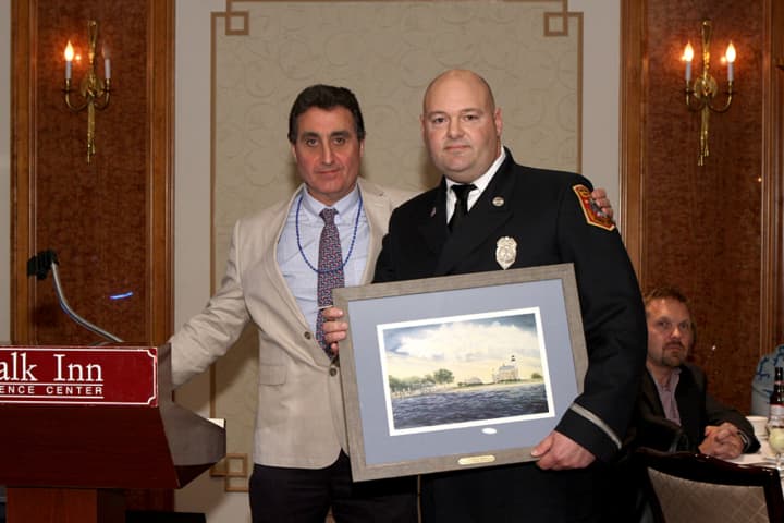 Vincent Schitano, Norwalk Seaport Association president, presents the Beacon Award to Lt. Pirro at the recent gala.