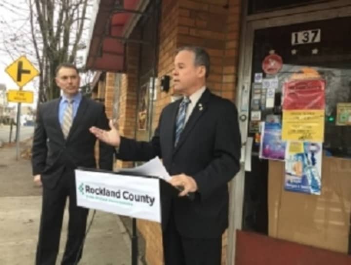 Rockland county Executive Ed Day stands in front of a cafe and market on North Main Street in Spring Valley as he announces the county&#x27;s intentions to auction 16 properties for back taxes. To Day&#x27;s right is Tom Dillon, the county&#x27;s title examiner.