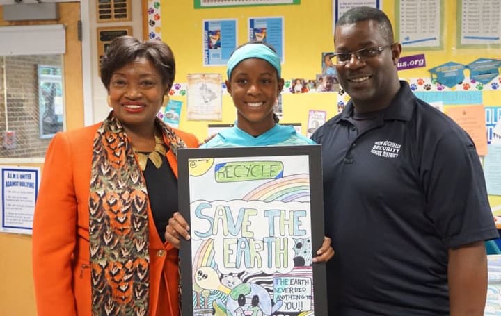 Olivia Moxey holding her winning Earth Day poster with her father and State Sen. Andrea Stewart-Cousins