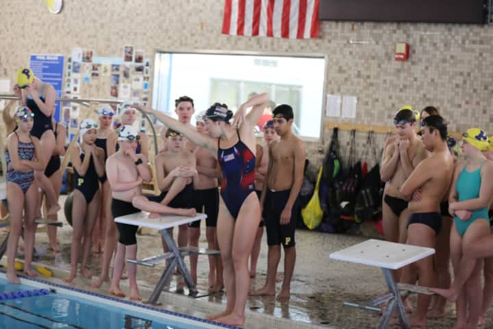 Olympian Maya DiRado demonstrates a technique to Darien Y Piranhas swimmers.